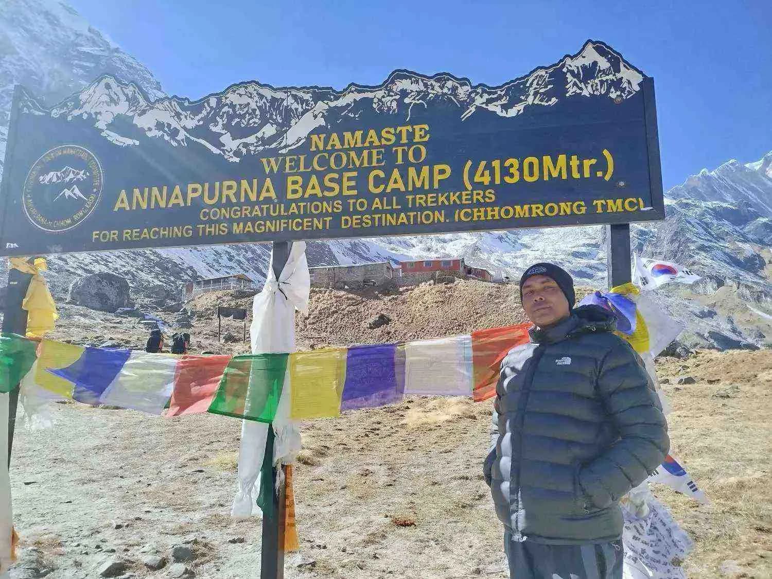 trekker standing beside sign board in abc trek