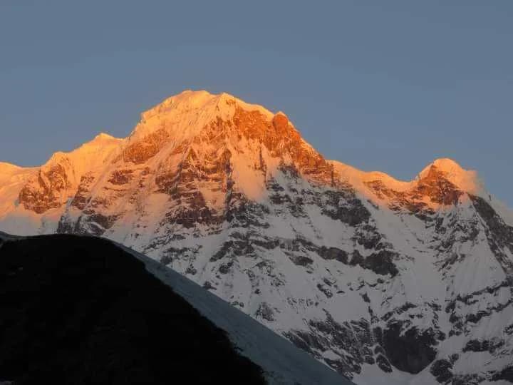 Golden sunset light hitting the snowy summit of Annapurna South during an ABC and Poon Hill trek Golden sunset light hitting the snowy summit of Annapurna South during an ABC and Poon Hill trek