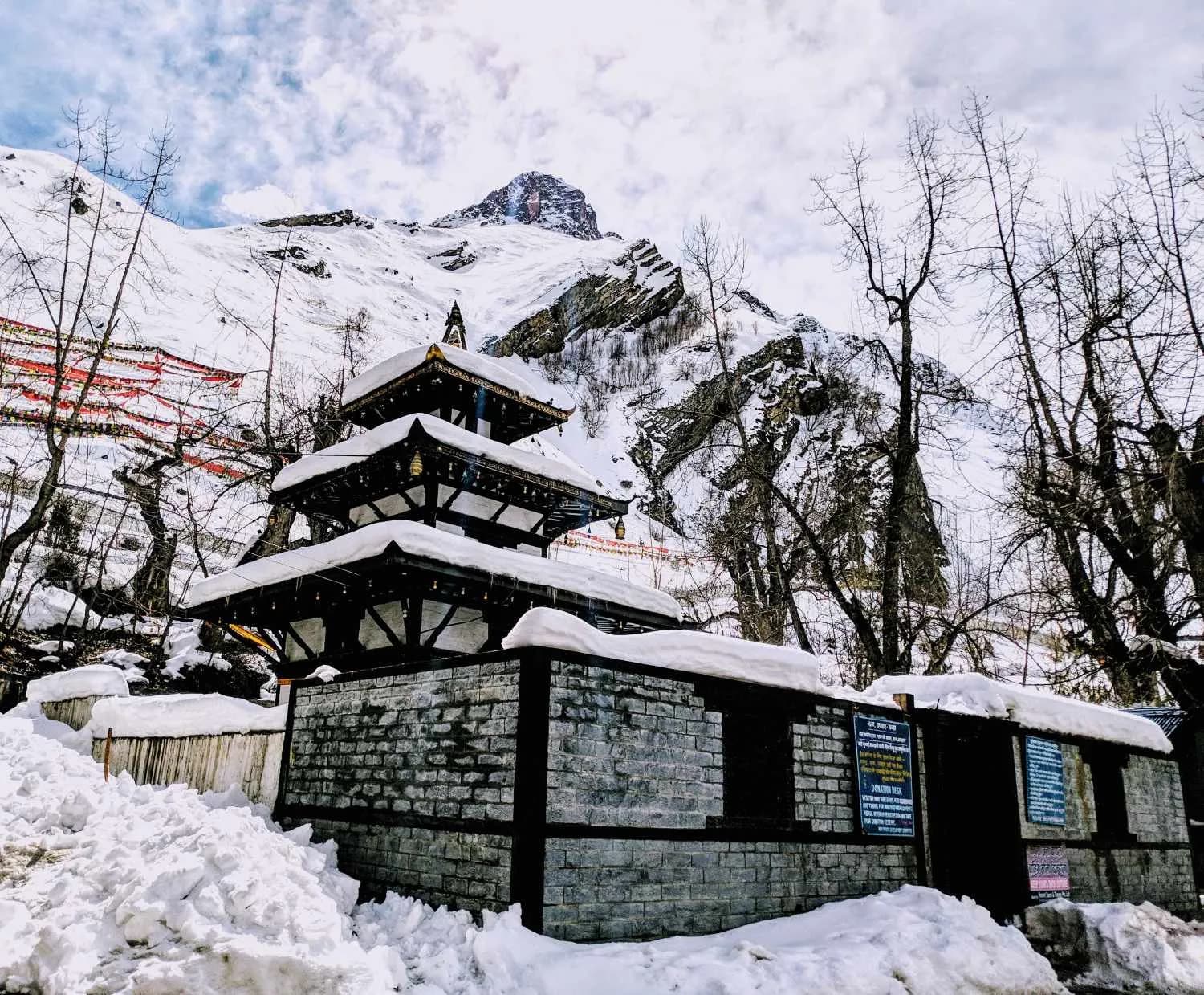 The multi-tiered Muktinath Temple covered in deep winter snow against a mountain backdrop The multi-tiered Muktinath Temple covered in deep winter snow against a mountain backdrop