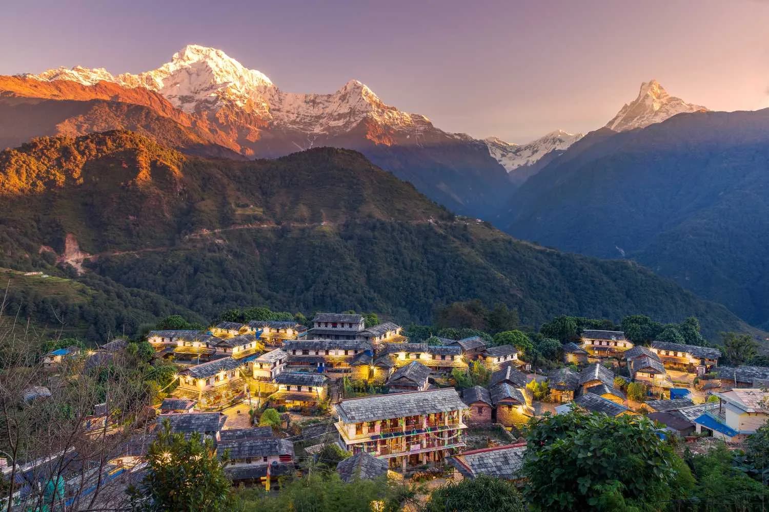 Ghandruk village glowing with lights at twilight beneath the golden peaks of Annapurna and Machhapuchhre Ghandruk village glowing with lights at twilight beneath the golden peaks of Annapurna and Machhapuchhre